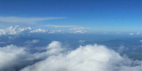 The view from above the clouds: a flat white cloud-top under open blue sky.